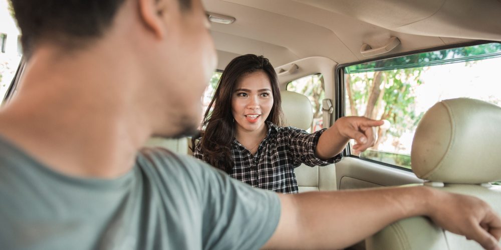 female taxi customer pointing her direction to the driver